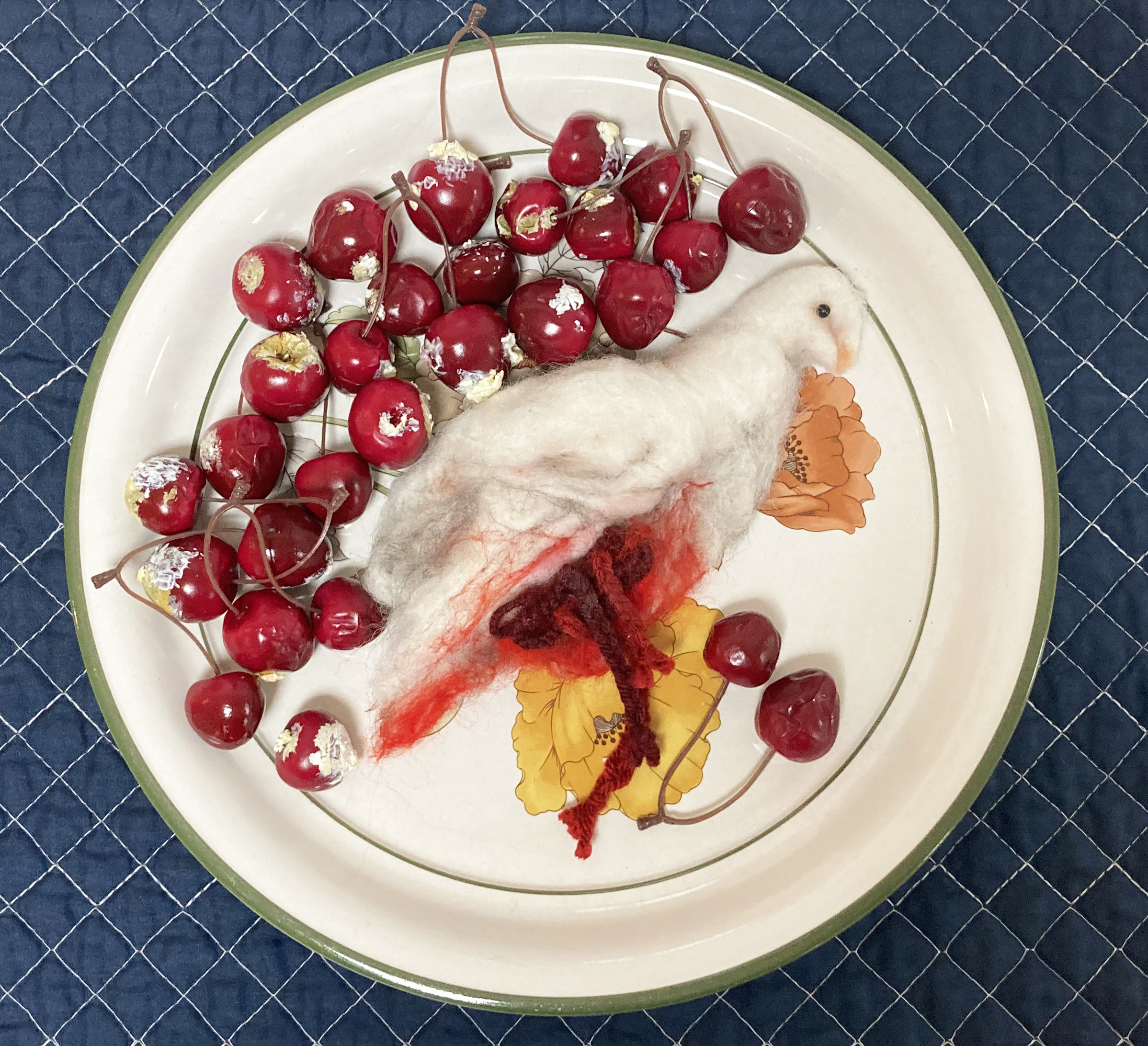 Cost of Freedom, needle felt, plastic cherries, ceramic plate, and fabric, 2023